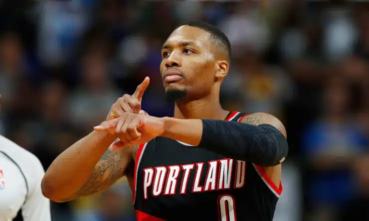 a photo of Damian Lillard pointing his arm to indicate a clock